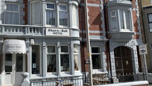 A Victorian-style building with a sign reading "Sharn Bek Hotel".