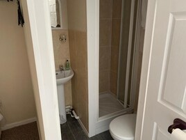 Een badkamer met toilet, wastafel en douche.