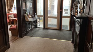 A lobby with a reception desk, a seating area, and a glass door leading outside.
