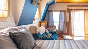 A bedroom with a bed, a chair, a desk, and a window with curtains. - The most wanted place to stay in Cheticamp (Chéticamp)