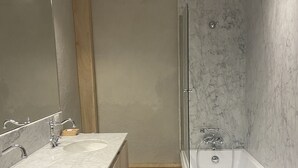 Un baño moderno con dos lavamanos, un inodoro y una bañera.
