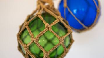 A close-up of a green glass object with a rope net, and a blue glass object.