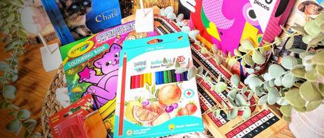 Variedad de libros y materiales para colorear, incluyendo un libro titulado 'Cats' de Hans Silverstein, un libro de colorear y un juego de crayones.