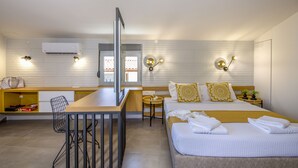 A hotel room with a bed, bedside table, chair, and a small desk area. - Casa Di Camomilla (Platanias)