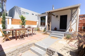 Enjoy a patio with a table and chairs, a charming porch, and a stone pathway leading to the entrance.