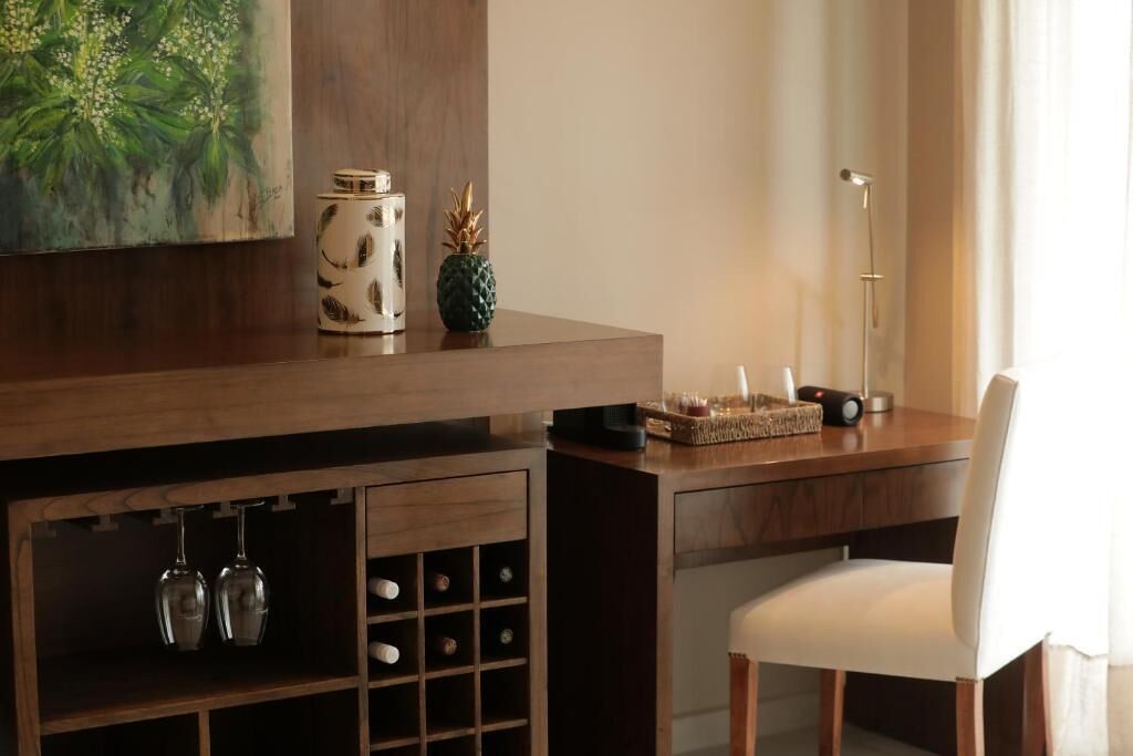 A wooden desk with a white chair, a small plant, and a decorative item on the desk.