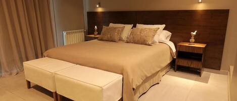 A modern bedroom with a large bed, two bedside tables, and a bench.