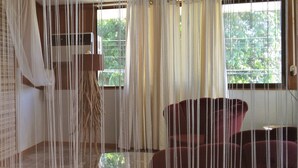 Una habitación con un ventanal grande, un sofá rojo y una lámpara colgante.