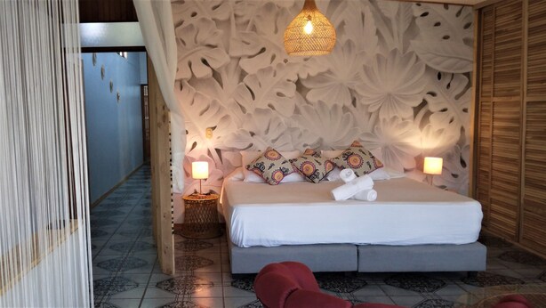 Un dormitorio con una cama grande, dos lámparas de noche y un adorno en la pared.