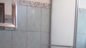 Un baño con inodoro, ducha y toallero.