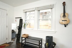 Relax in this stylish room with a large window, guitar, and snowboard, perfect for music lovers and adventure seekers.