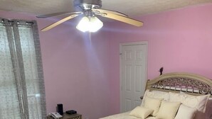 A bedroom with a bed, a nightstand, a ceiling fan, and a window with curtains. - Nice to meet you (Jackson)