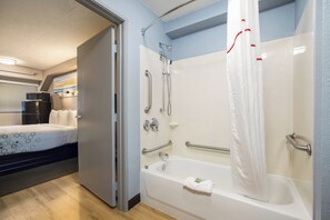 A bathroom with a bathtub, shower, and handrails. - HomeTowne Studios By Red Roof Princeton – Ewing/ Lawrenceville (Lawrenceville)