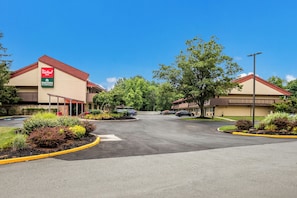 Un Red Roof Inn con estacionamiento y jardines.
