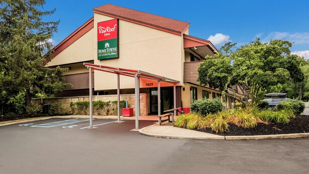Un Red Roof Inn con entrada cubierta y estacionamiento.