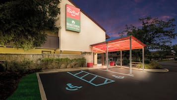 Un hotel Red Roof Inn con entrada cubierta y estacionamiento para discapacitados.