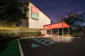 Un hotel Red Roof Inn con entrada cubierta y estacionamiento para discapacitados.