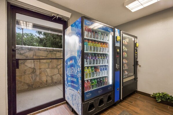 Máquina expendedora con diversas bebidas y dispensador de agua.