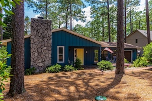 Set amidst a serene wooded area, this property offers a retreat with a beautifully maintained garden and a pathway leading to the front door.