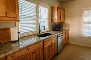 Enjoy cooking in this well-equipped kitchen with a sink, coffee maker, and dish rack.