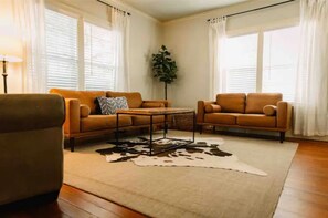 Relax in this stylish living room with a cowhide-patterned rug, two comfortable sofas, and a tall green plant.
