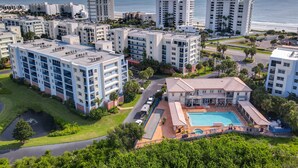 Complejo residencial de edificios altos con piscina y vista al océano.