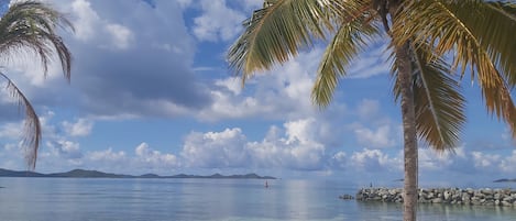 Am Strand, weißer Sandstrand, Liegestühle, Sonnenschirme