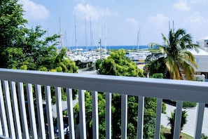 A marina with multiple sailboats docked, surrounded by lush greenery and palm trees. - Nanny Cay Resort and Marina (Road Town)