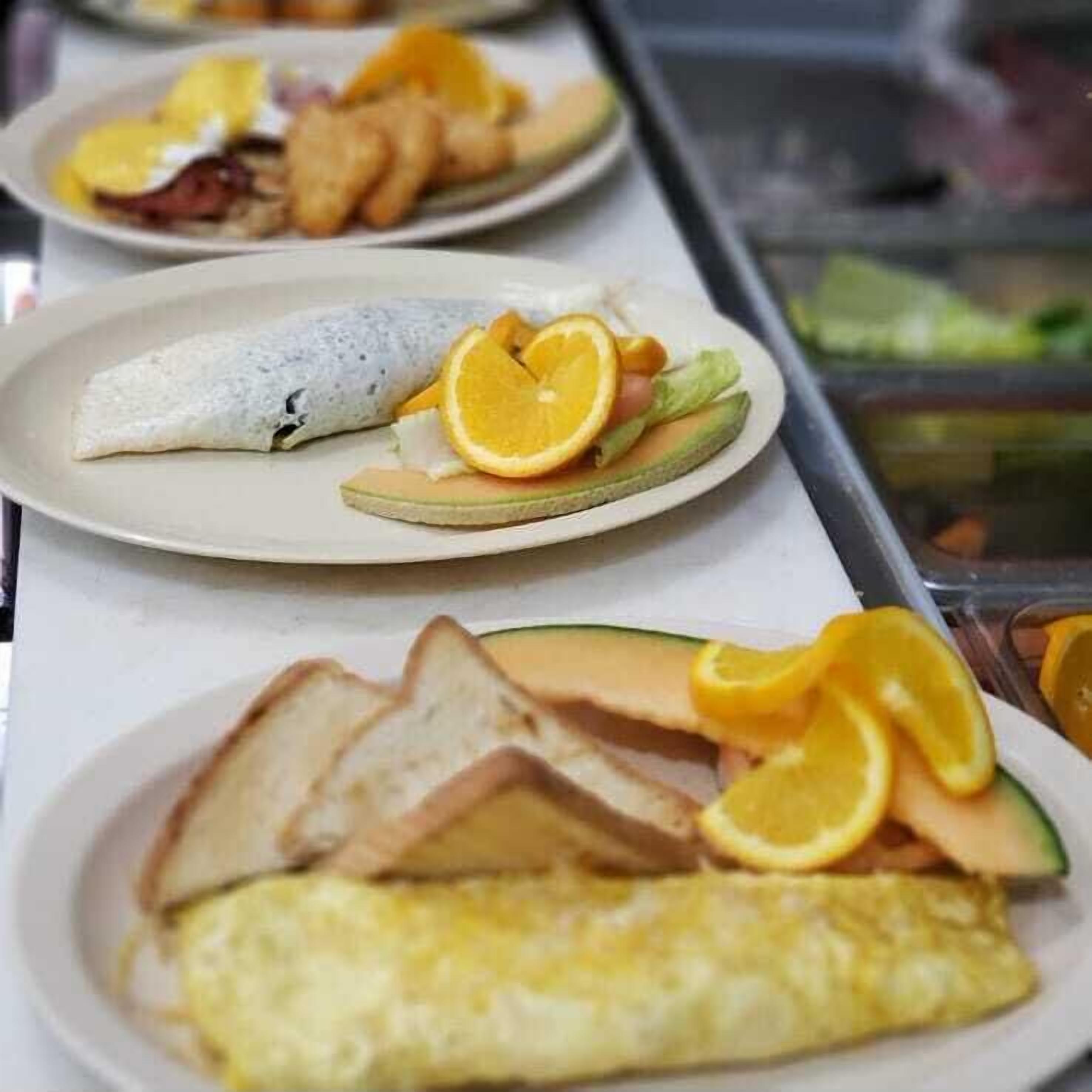Un bufé de desayuno con diversos platos, como tortillas, tostadas y fruta.