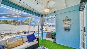 A covered outdoor seating area with a pool, a ceiling fan, and motivational wall signs. - Welcome to Alena's Place! Only minutes away from Disney! (Kissimmee)