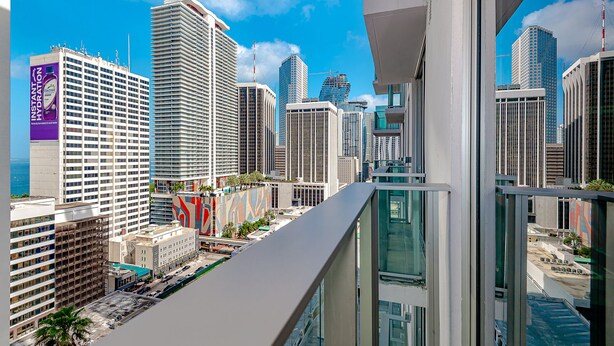 A high-rise building with a modern architectural design, featuring a glass facade and a rooftop terrace. - Gorgeous Studio in Downtown Miami - #1911 (Miami)
