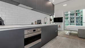 A modern kitchen with grey cabinets, white countertops, and a built-in oven. - Gorgeous Studio in Downtown Miami - #1911 (Miami)