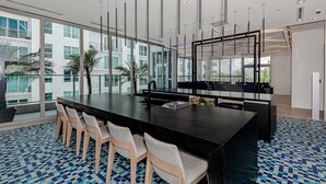 A modern conference room with a long table, several chairs, and a view of a building with large windows. - Gorgeous Studio in Downtown Miami - #1911 (Miami)