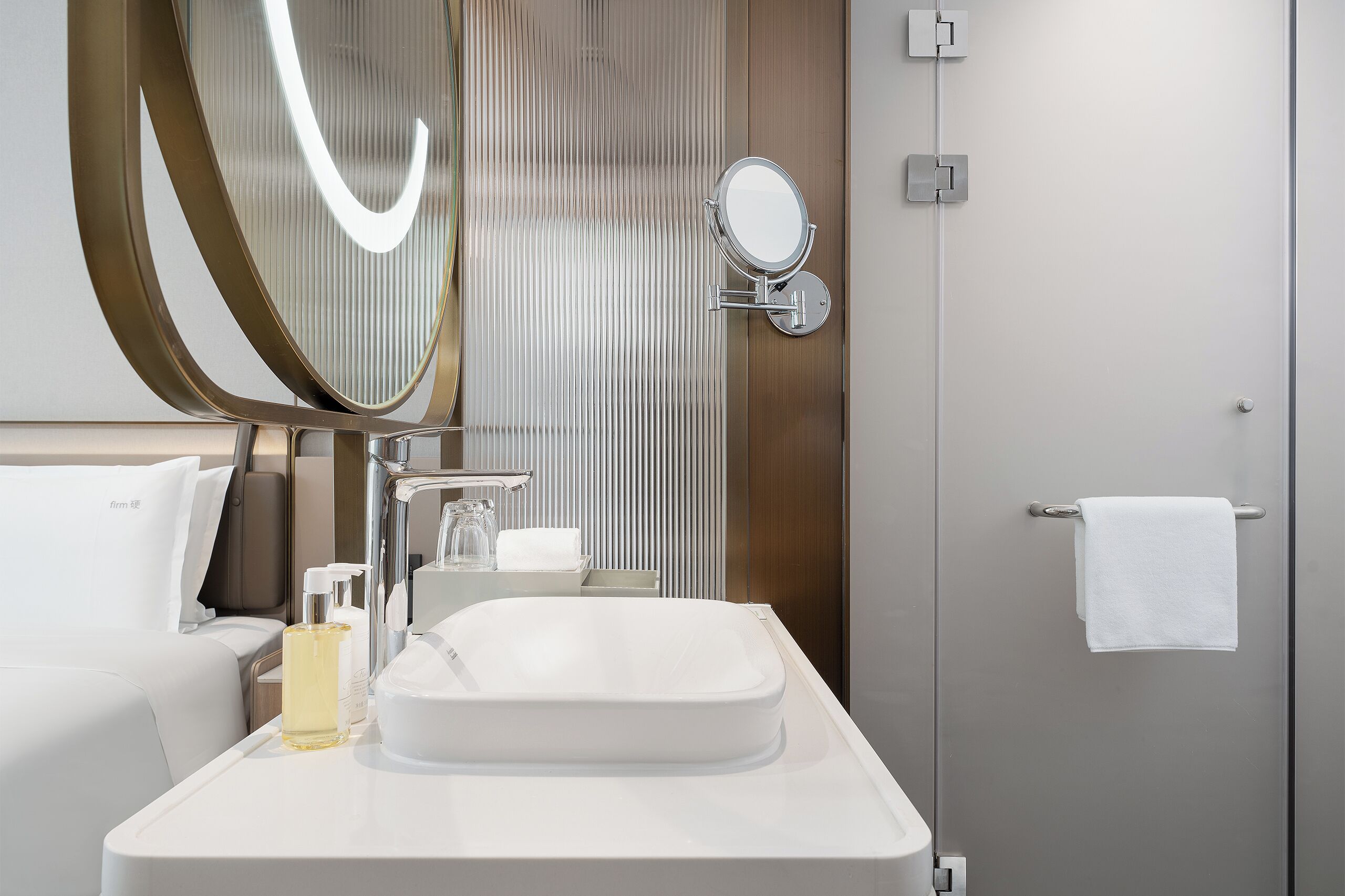 A modern bathroom with a large mirror, a sink, and a towel rack.