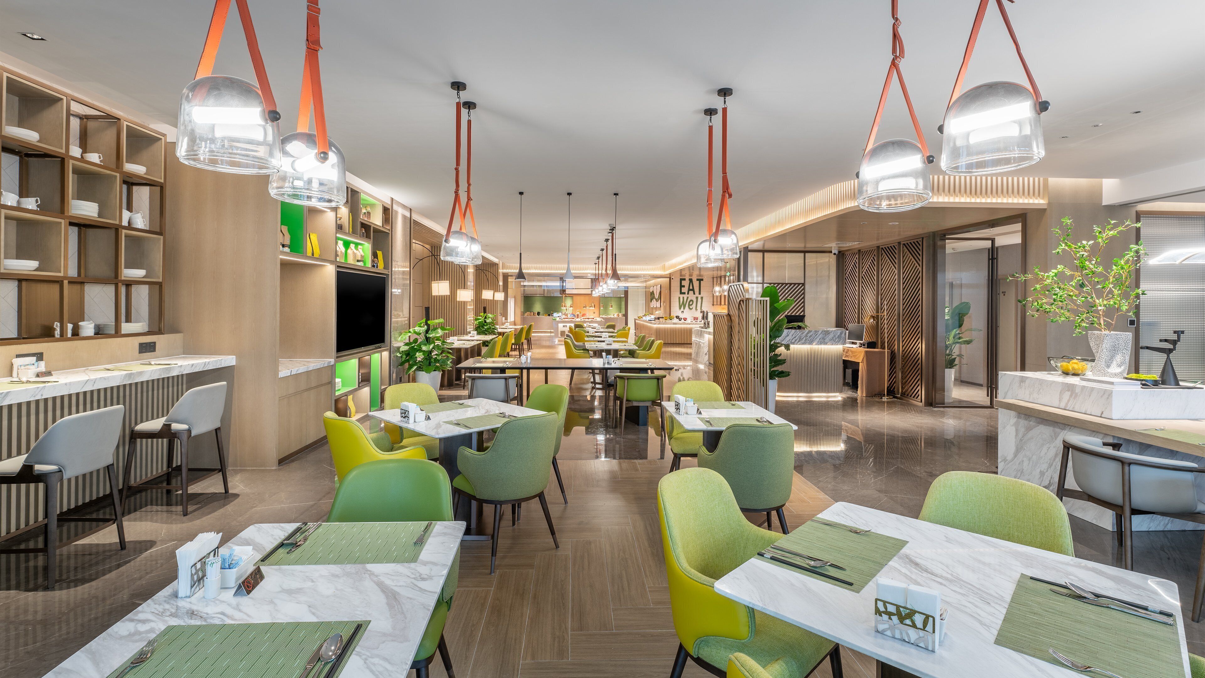 A modern restaurant with a central dining area, multiple seating options, and a visible kitchen area.
