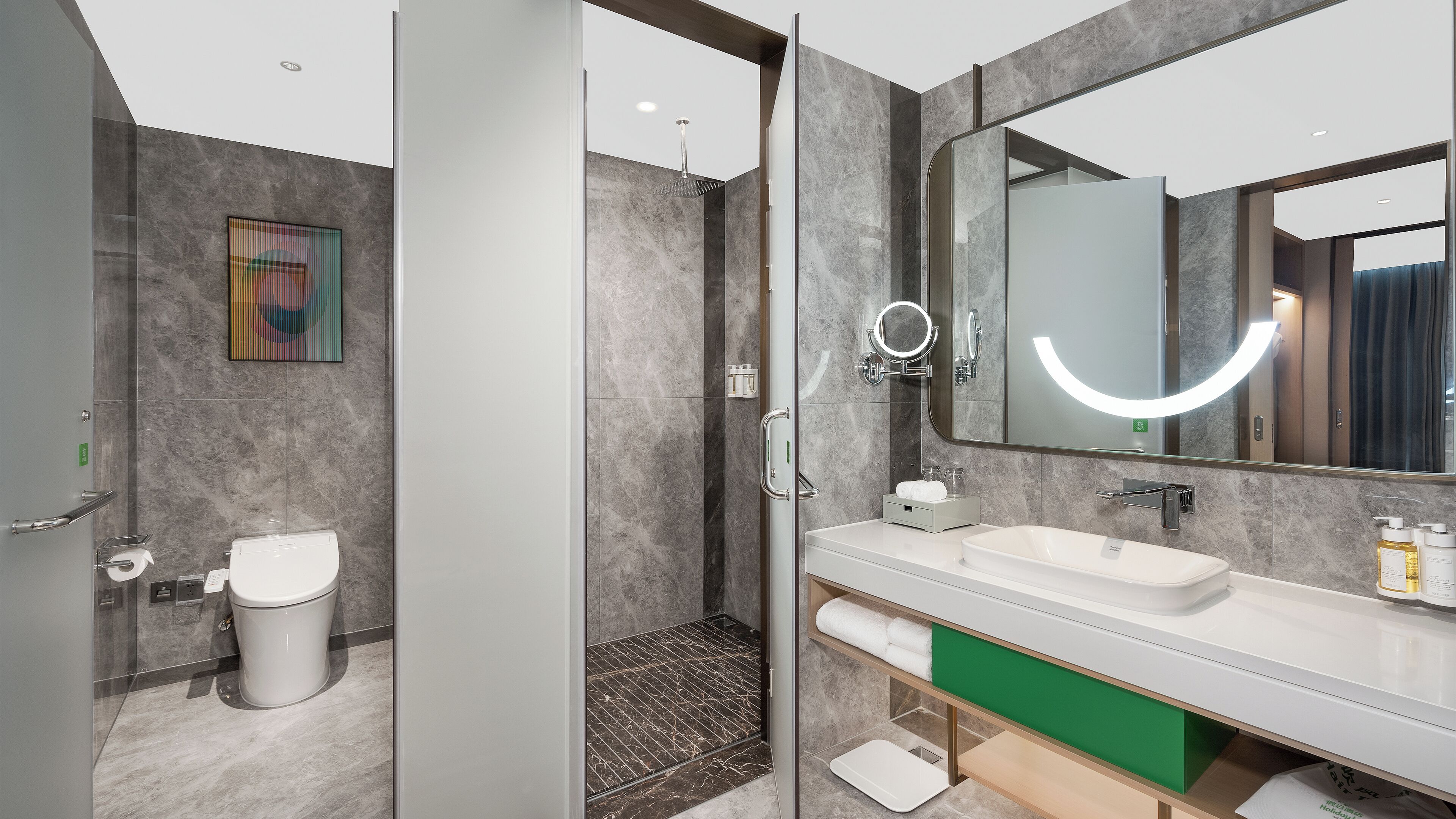 Un baño moderno con ducha envuelta en vidrio, un espejo grande y un lavamanos blanco.