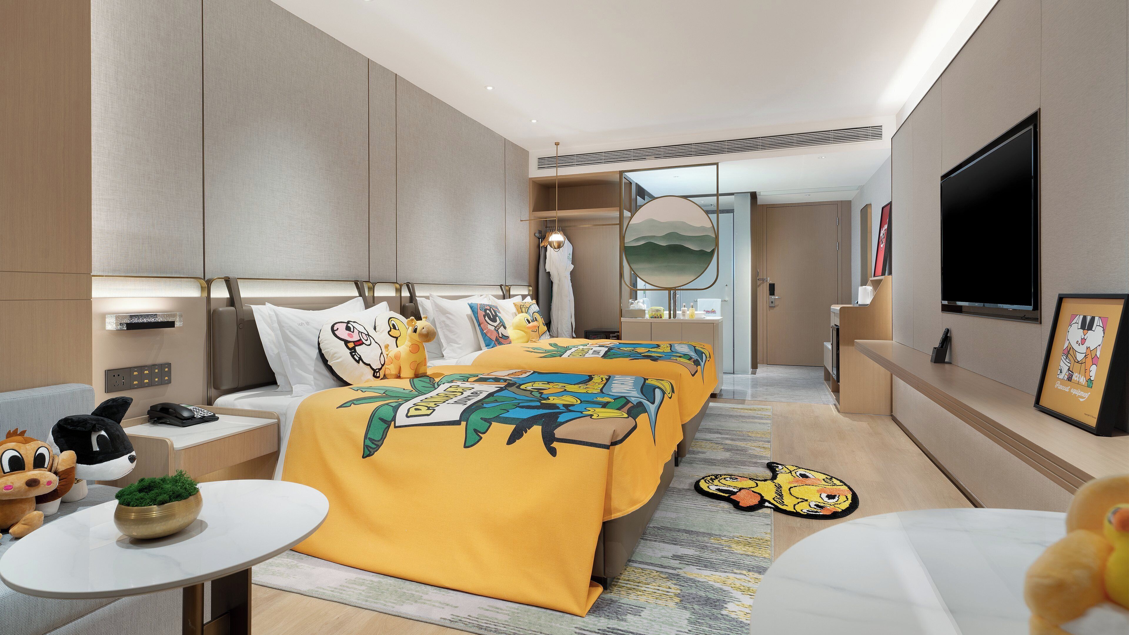 Una habitación de hotel moderna con cama, mesitas de noche, escritorio y televisor.