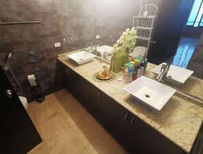 Ein modernes Badezimmer mit zwei Waschbecken, einem großen Spiegel und einem Handtuchhalter.