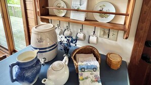A kitchen counter with various kitchenware, a clock, and a display of plates on a shelf. - Vista Greystone Lodge-Incredible view!! Streaming tvs! Wifi! Private! Sleeps 10! (Talking Rock)