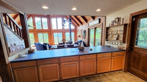 A spacious kitchen with wooden cabinets, a large island, and a view of the outdoors through large windows. - Vista Greystone Lodge-Incredible view!! Streaming tvs! Wifi! Private! Sleeps 10! (Talking Rock)
