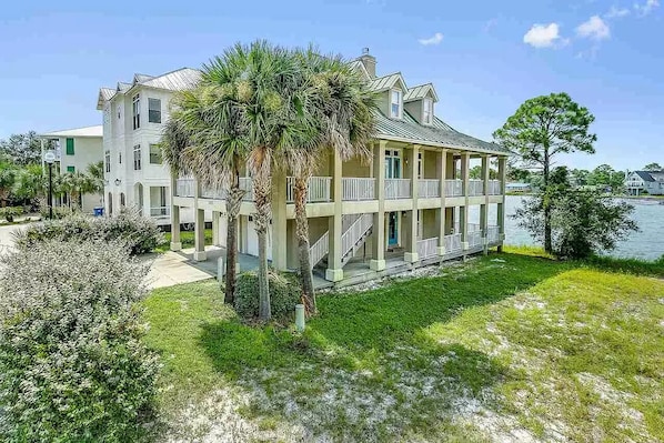 A large, multi-story building with a balcony overlooking a body of water.