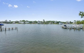 A calm lake with docks and houses in the background.