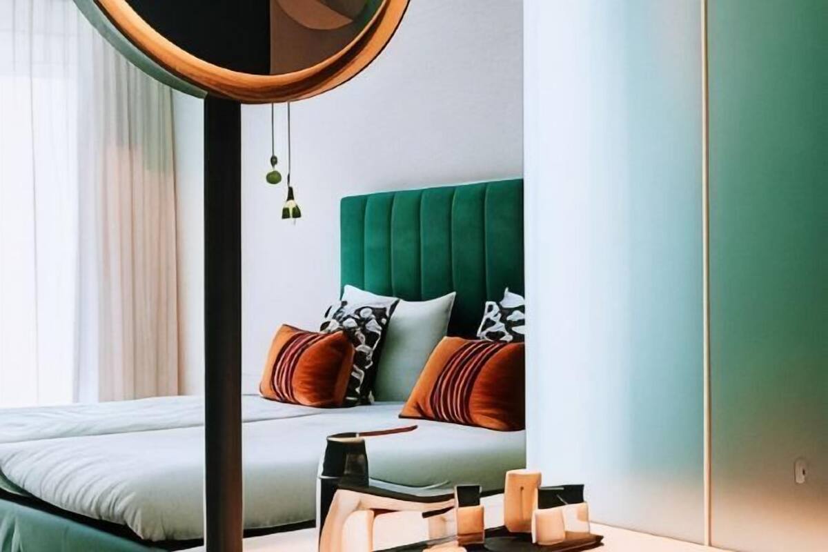 A bedroom with a bed, bedside table, and a green headboard.