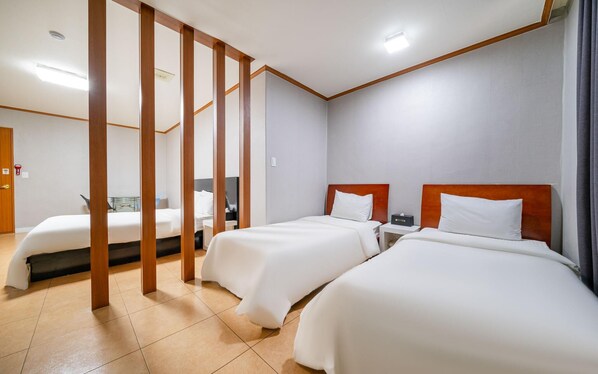 A hotel room with two beds, wooden headboards, and a tiled floor. - Donghae Lisa Hotel (Donghae)