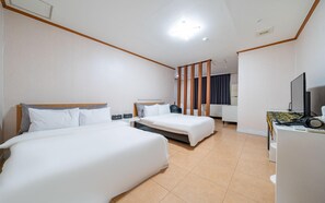 A hotel room with two beds, a desk with a computer, and a TV. - Donghae Lisa Hotel (Donghae)