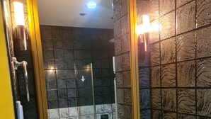 A bathroom with a large mirror, a white sink, and a wall with a textured pattern. - PICO DE LORO ROOM FOR RENT by BILLYN HAMILO COAST, BATANGAS (Nasugbu)