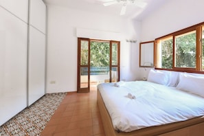 A bedroom with a bed, a ceiling fan, and a view through a glass door to an outdoor area. - Penthouse • Terrace & City Views by SeaNRent (Tel Aviv-Yafo)