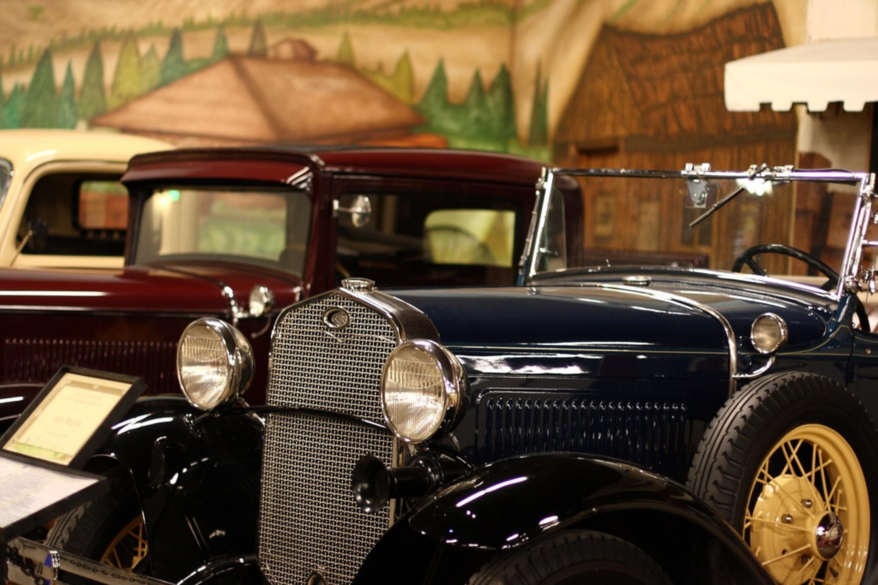 A vintage car with a classic design, including a prominent grille and round headlights.
