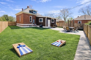 En baghave med en patio, et murstenshus og to shuffleboard-borde.