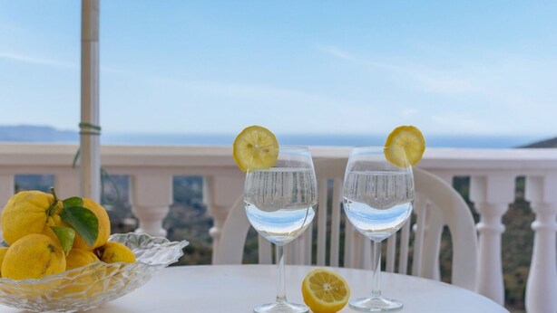 Two glasses of water with lemon slices on a balcony table with a view of the sea. - Villa Paco At Home Torrox by Ruralidays (Málaga)